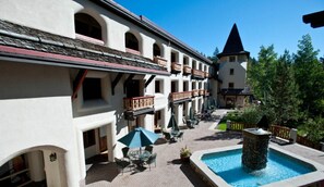 A courtyard with a pool, outdoor seating, and a building with balconies. - Squaw Valley condo, sleeps 4, all amenities, walk/shuttle to lifts (Olympic Valley)