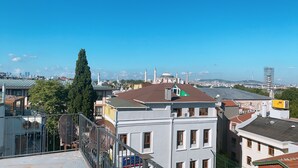 A view of a cityscape with a prominent mosque with a dome and minarets, surrounded by residential buildings and a clear blue sky. - Redamancy Hotel (Istanbul)