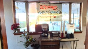 Una cocina con cafetera, licuadora y señal de precaución.
