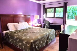 Una habitación con cama, escritorio, silla y ventana con cortinas.