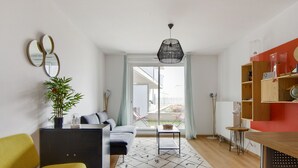 A modern living room with a sofa, a yellow chair, a small table, and a potted plant. - Appartement Corselle - Welkeys (Mouvaux)