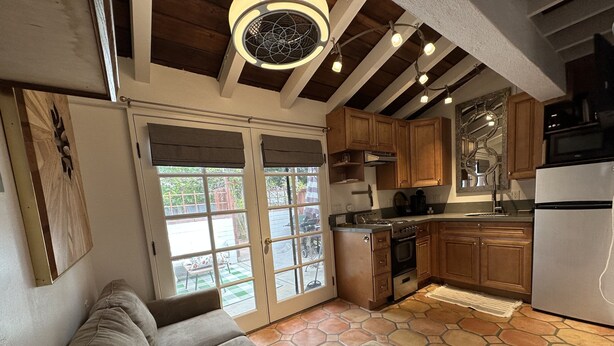 A modern kitchen with wooden cabinets, a built-in oven, and a refrigerator. - El Bungaló Privado (San Clemente)