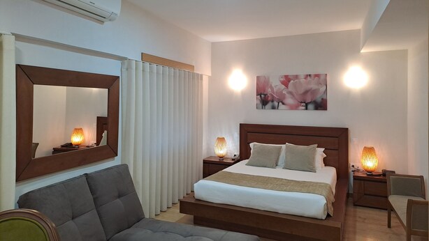 Un dormitorio moderno con una cama grande, lámparas de noche, un espejo y una luz en el techo.