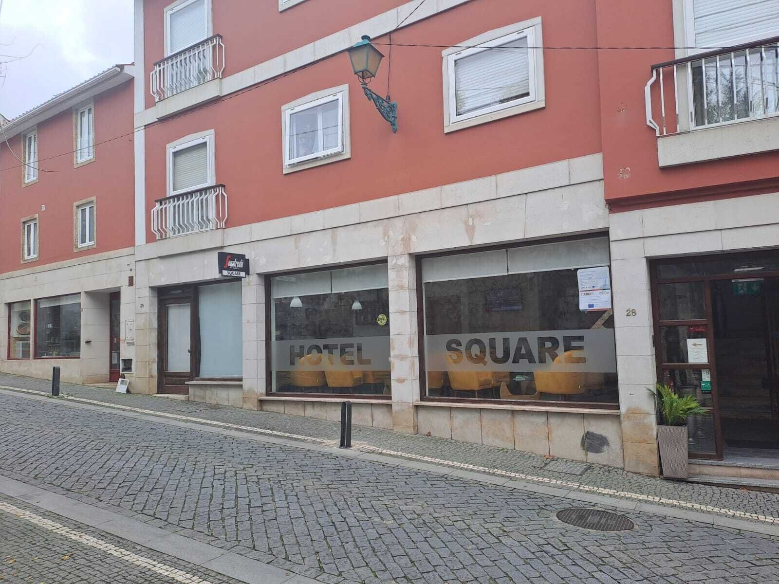 Un hotel con un letrero que dice 'HOTEL SQUARE' y una entrada visible.