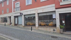 Un hotel con un letrero que dice 'HOTEL SQUARE' y una entrada visible.