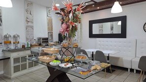 A breakfast buffet with various food items and a decorative centerpiece. - Hotel Square (Serta)