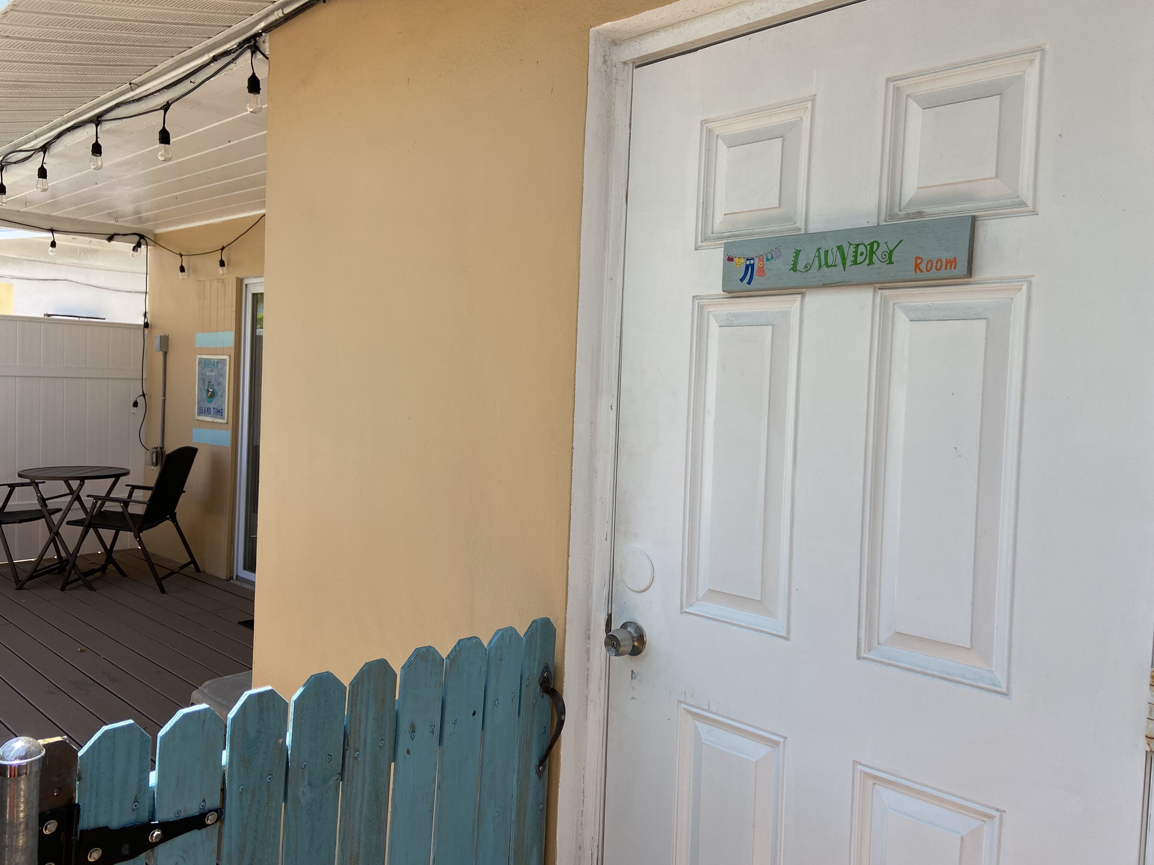 A room with a door labeled "Laundry Room" and a small table with chairs.