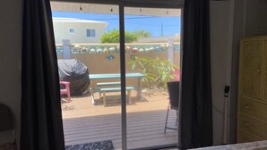 Une pièce dotée d’une porte-fenêtre coulissante donnant sur un patio extérieur.
