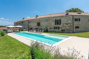 A stone building with a swimming pool, outdoor seating, and a well-maintained lawn. - Aquileia Residence # 5 - peaceful, private garden, large pool, close to Grožnjan (Grožnjan)