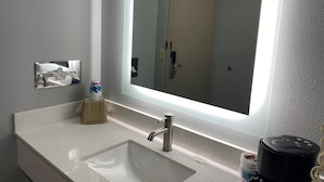 A bathroom with a large mirror, a sink, and a toilet. - AmericInn by Wyndham Viroqua (Viroqua)