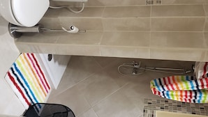 A bathroom with a toilet, bidet, and a shower area.