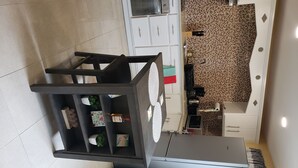 A modern kitchen with white cabinets, a tiled backsplash, and a grey refrigerator.