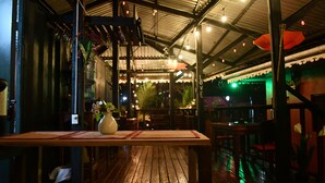 An indoor restaurant with wooden flooring, tables, and chairs. - Hotel Casa Vito (Cahuita)