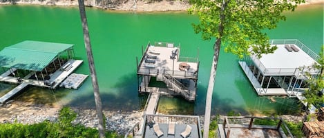 A dock with a covered seating area, a small deck, and a fire pit.