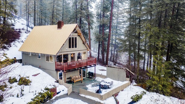 A two-story house with a balcony, surrounded by a snowy landscape and tall trees. - Leavenworth Cabin Close To Town And Jaw Dropping View! (Leavenworth)