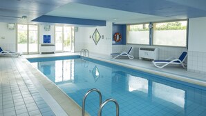 A swimming pool with clear blue water, tiled walls, and a lifebuoy on the wall. - Studio Rustic le Long de la Route des Vins (Bergheim)