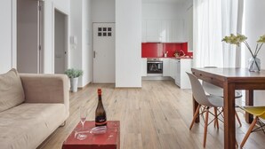 Een modern appartement met een woonkamer, een eetgedeelte en een keuken.