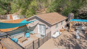 Una casa con piscina, mobiliario exterior y una terraza de madera.