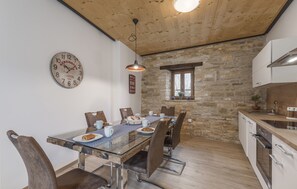 A dining area with a glass table, six chairs, and a clock on the wall. - Aquileia Residence # 4 - peaceful, private garden, large pool, close to Grožnjan (Grožnjan)
