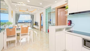 A modern kitchen with a built-in oven, a coffee maker, and a view of the sea. - Muong Thanh Apartment (Da Nang)
