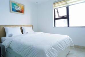 Une chambre avec un lit, une fenêtre donnant sur un beau paysage et un tableau accroché au mur.
