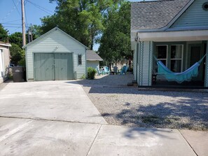 A residential property with a garage, a covered porch, and a hammock.