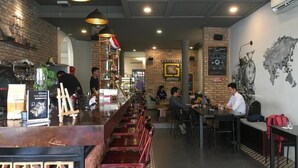 Interior de restaurante con una barra larga, zona de mesas y una pared de ladrillo con el logo de Jeep.