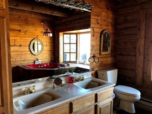 A wooden cabin bathroom with a sink, mirror, toilet, and window. - Cliffside Log Cabin w/  Large Deck for Enjoying Spectacular Views & Wildlife (Boise)