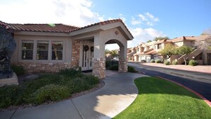 A residential building with a stone facade, a tiled roof, and a covered entrance. - PRIVATE GATED VACATION CONDO  WITH HEATED POOL, SPA, FITNESS ROOM, PATIO, GARAGE (Mesa)