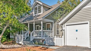 A two-story house with a covered porch, a garage, and a well-maintained yard.
