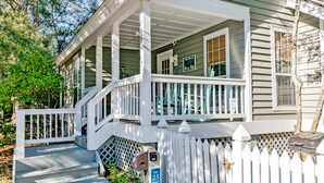 A two-story house with a covered porch, a mailbox, and a sign indicating a nearby restaurant.