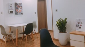 Een vergaderruimte met een witte tafel, vier stoelen, een potplant en kunstwerken aan de muren.