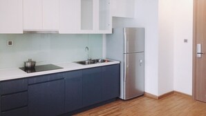 Een moderne keuken met witte kastjes, een roestvrijstalen koelkast en een inbouwoven.