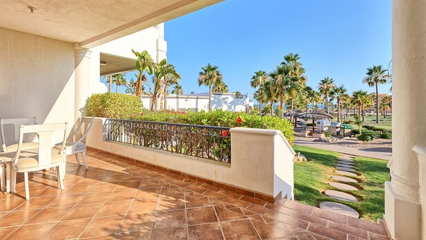 A covered outdoor area with tiled flooring, a railing, and chairs. - Casa Blanca CB-102 Let Me Count The Waves Beautiful View Condo (Puerto Peñasco)