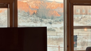 A room with a large window overlooking a mountainous landscape. - Capitol Reef Home with fast wi-fi and washer/dryer (Teasdale)
