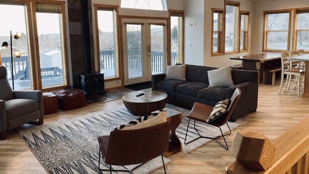 A spacious living room with a fireplace, large windows, and a cozy seating area. - Capitol Reef Home with fast wi-fi and washer/dryer (Teasdale)