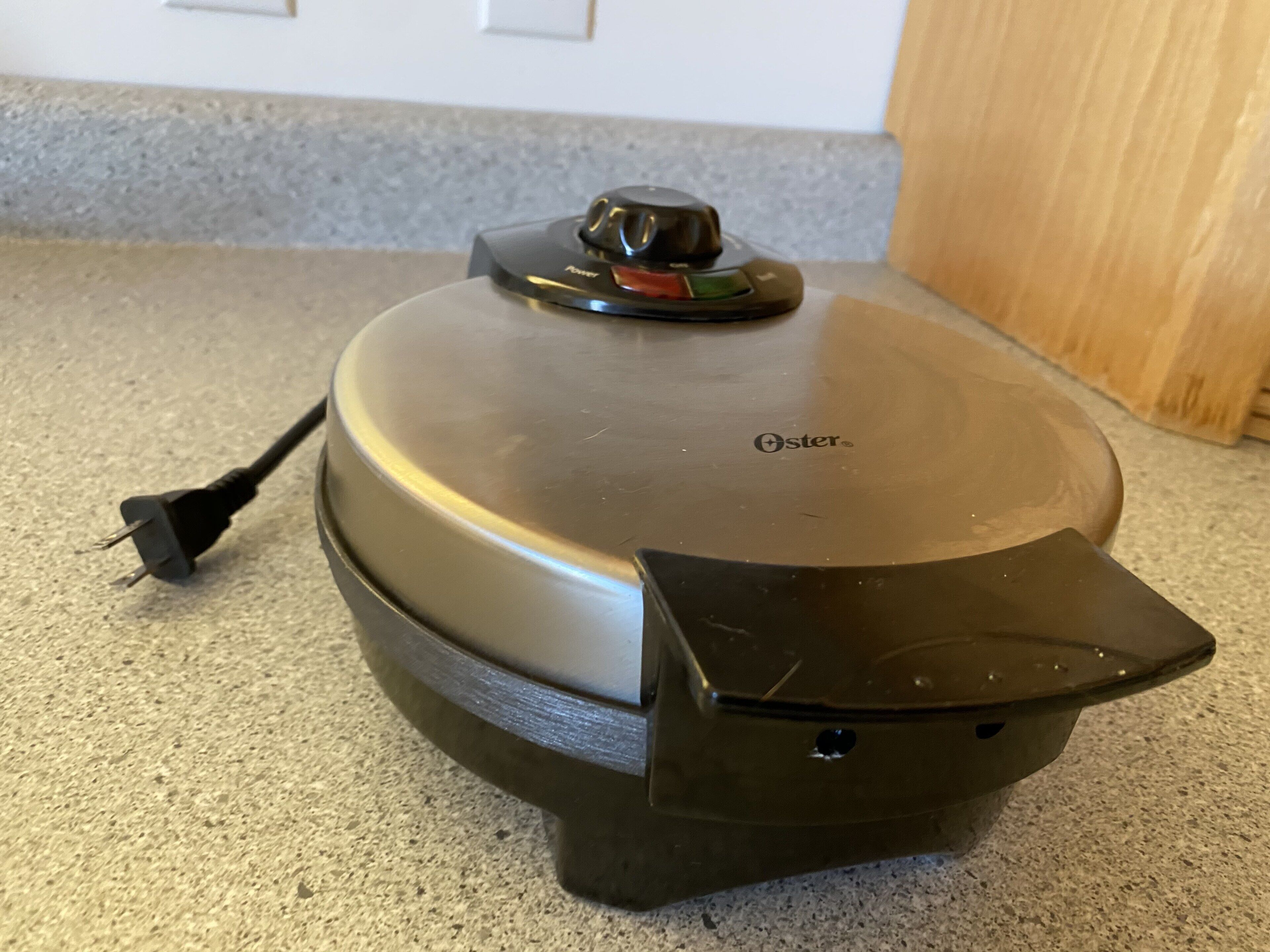 Een draadloze elektrische waterkoker met een aan/uit-knop en een snoer.