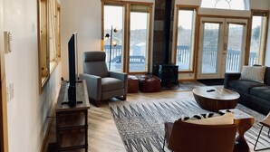 A spacious living room with a fireplace, large windows, and a balcony. - Capitol Reef Home with fast wi-fi and washer/dryer (Teasdale)