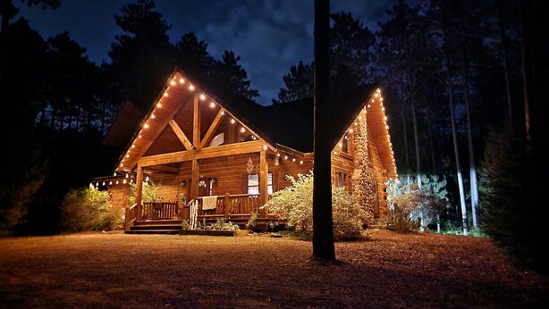 A log cabin with a porch, surrounded by trees. - 🏞Secluded Log Cabin Near Wisconsin Dells & Wisconsin River • Fireplace • Ski 🏕 (Lyndon Station)