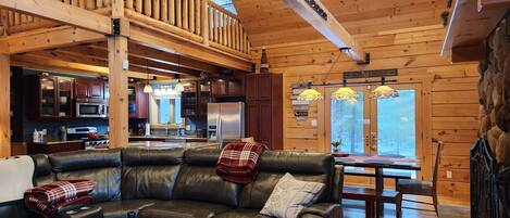 A cozy cabin interior with a living room, kitchen, and dining area.