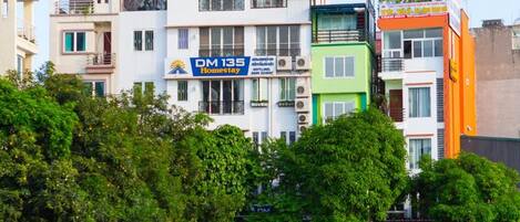Un edificio de varios pisos con un letrero que indica 'DM 135 Homestay', lo que sugiere un hotel u hospedaje.