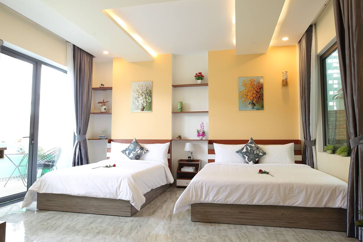 Een hotelkamer met twee bedden, een tafeltje en een stoel.