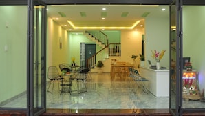 A modern interior with a staircase, dining area, and reception desk. - Lam Garden Boutique Homestay (Hue)