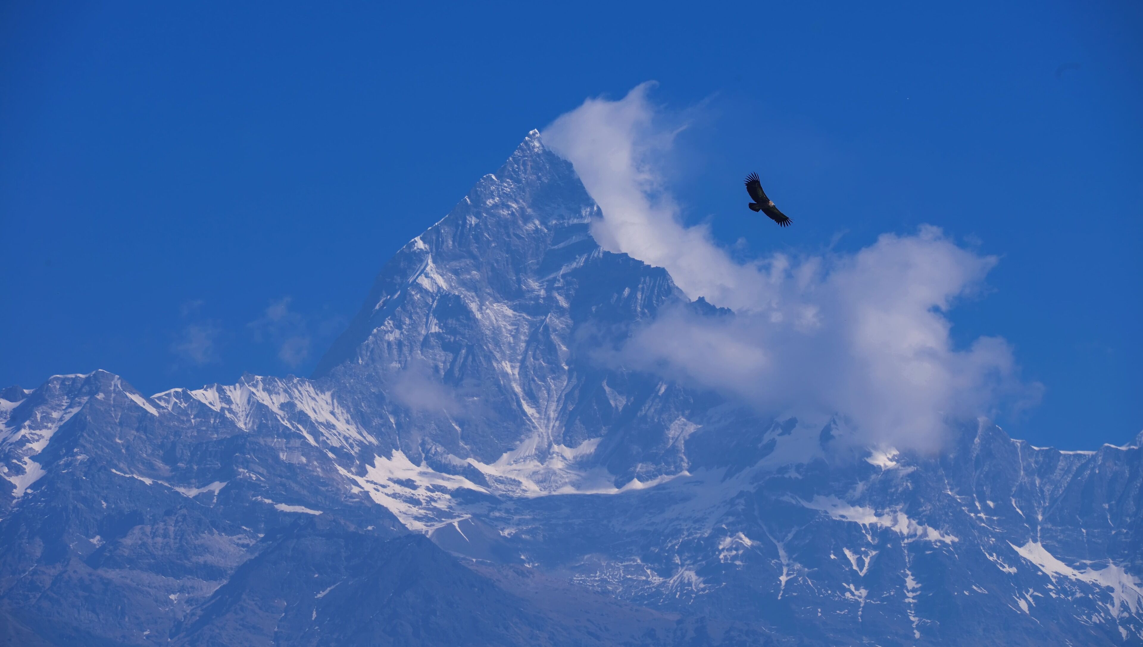 A mountain peak with snow and clouds.
