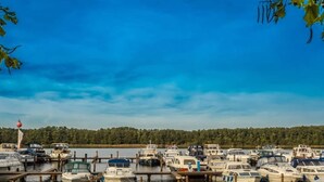 A marina with various boats docked at wooden piers. - Bootshaus in Mirow mit überdachter Terrasse (Mirow)