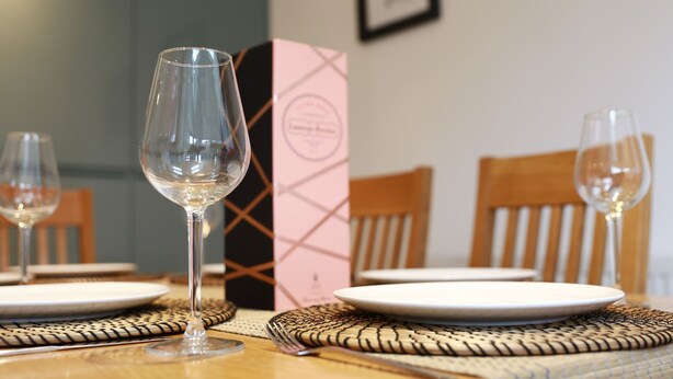 Une table à manger avec deux verres à vin, une assiette et une boîte.