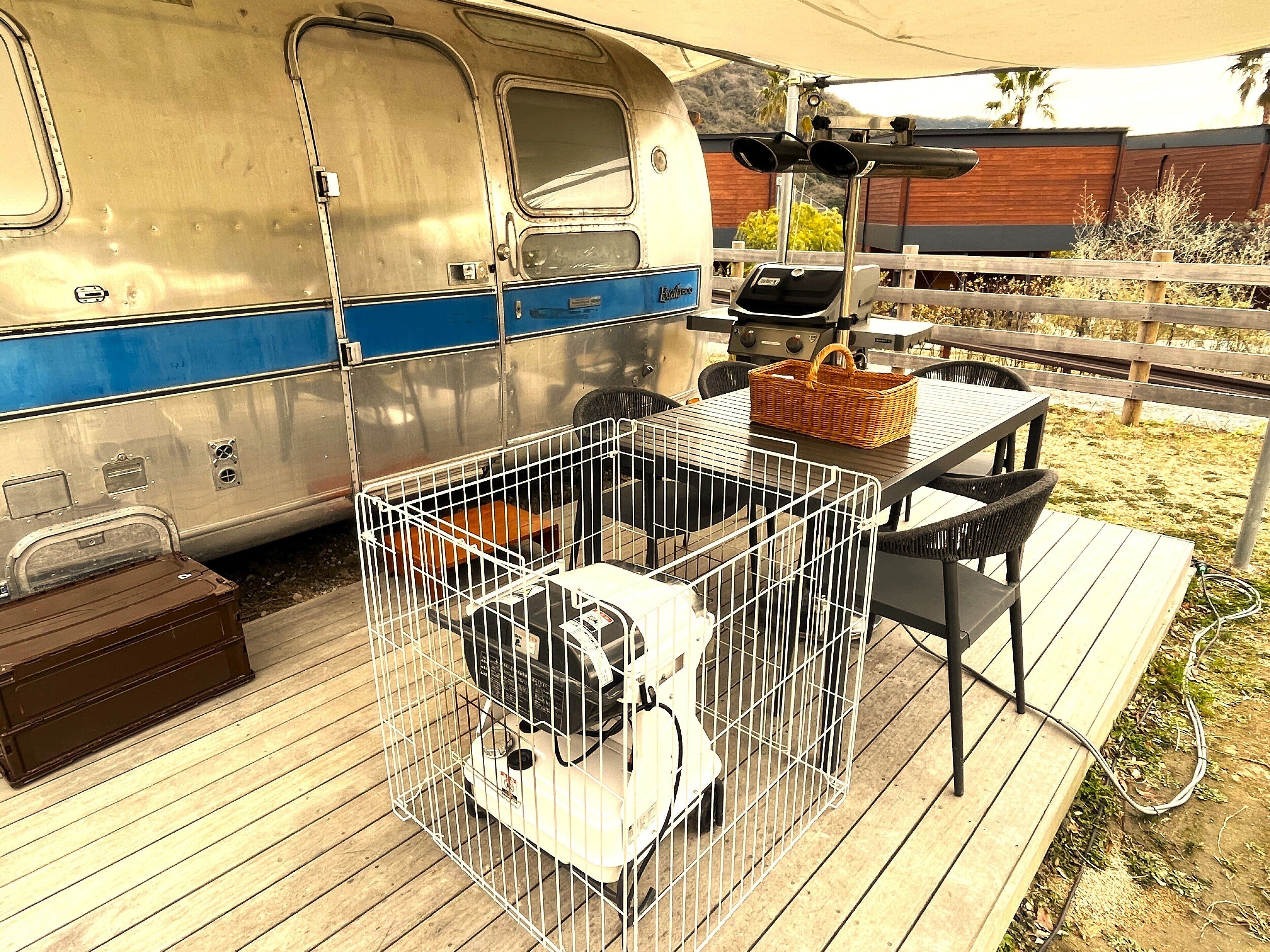 A stationary trailer with a kitchen area, a table, and a grill.