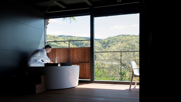 A modern room with a large window, a wooden floor, and a white chair. - THE Retreat (Iizuka)