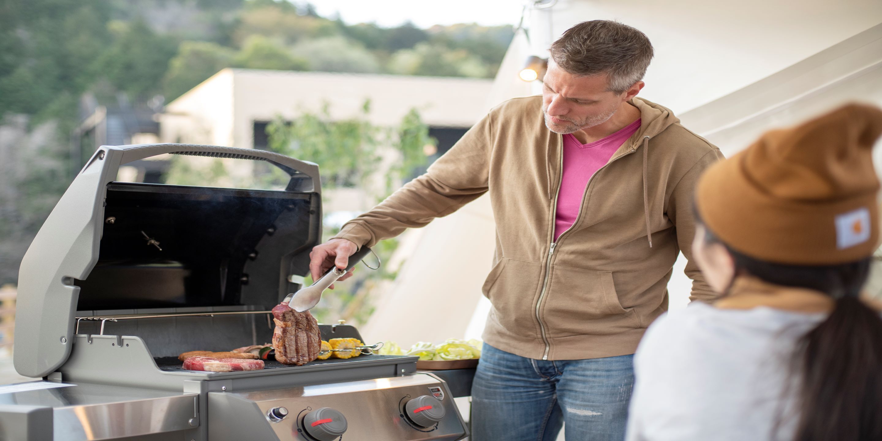 A person grilling meat on an outdoor grill.
