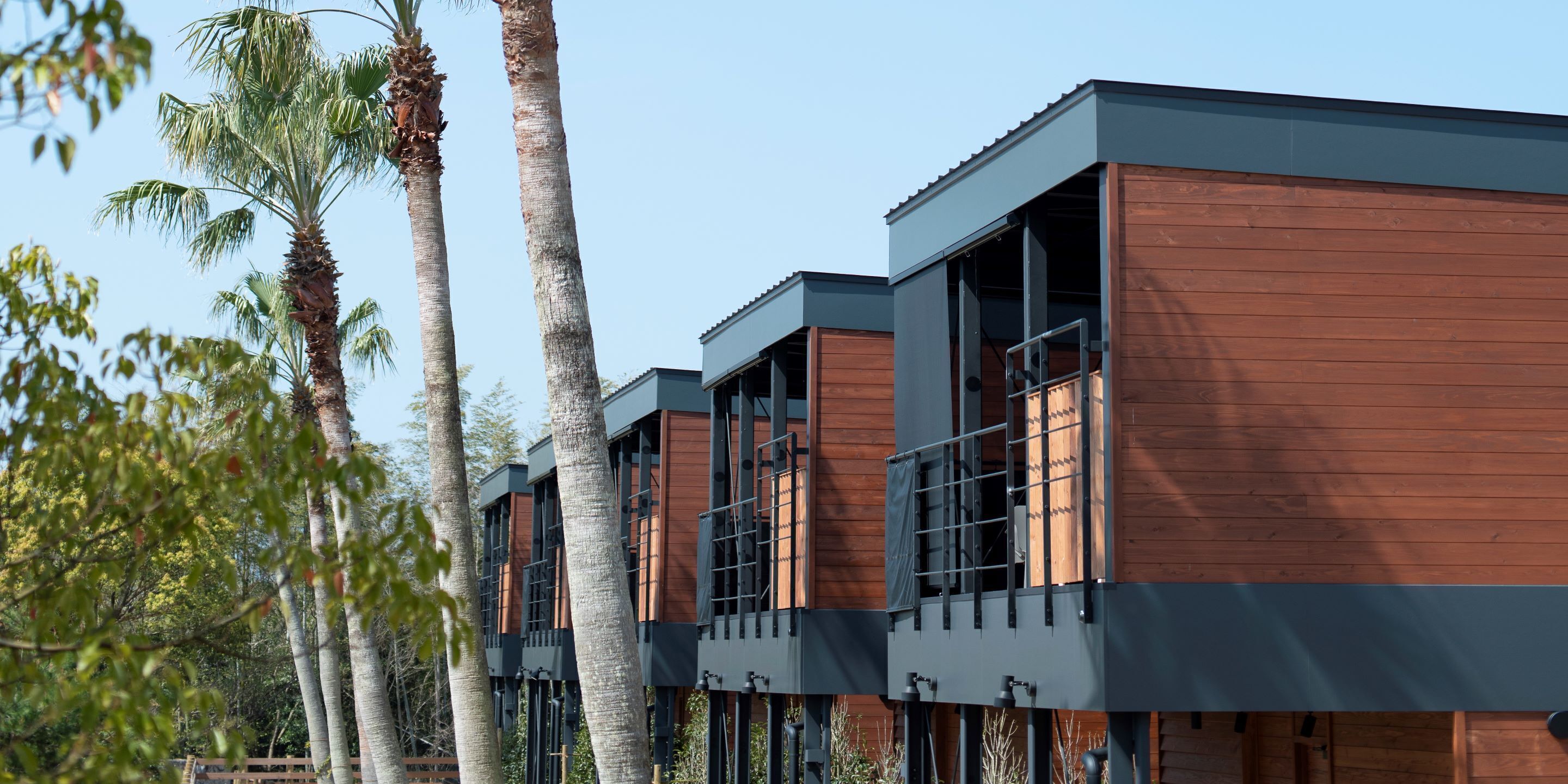 A modern building with multiple balconies and wooden paneling.